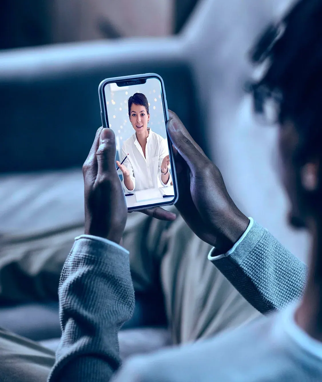 A patient holding a phone during a video visit with a sleep doctor