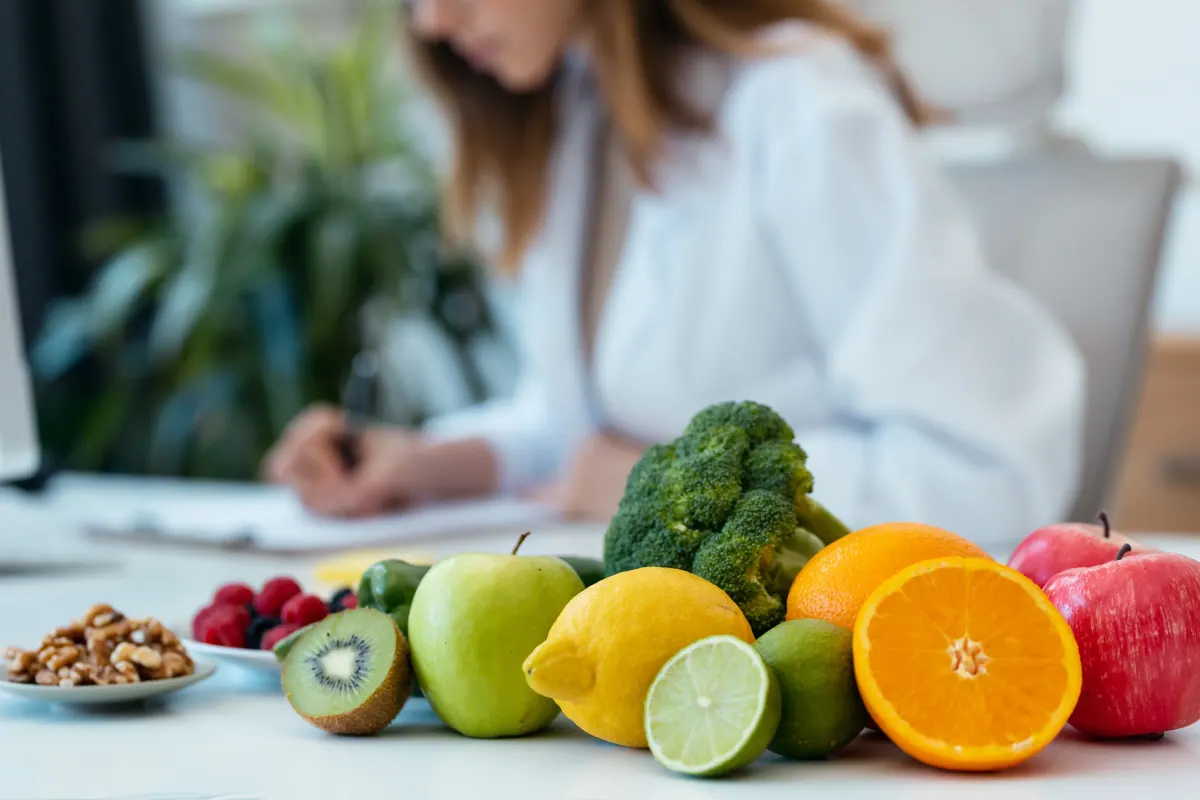 A functional nutritionist writing notes at a bright desk